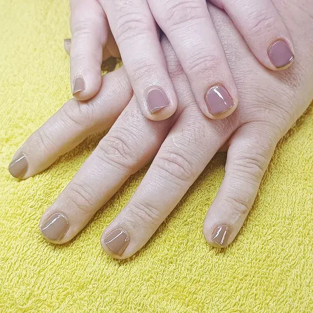 Deux mains aux ongles nude rosé